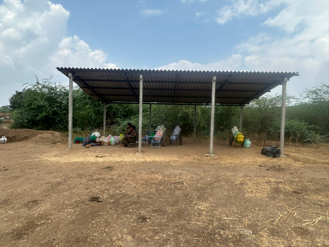 Women waiting in the shade for their turn to collect water
